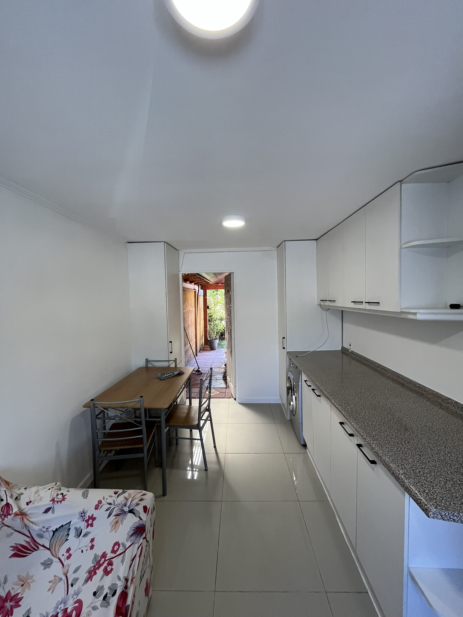 Cocina remodelada con muebles blancos e iluminación LED en Santiago