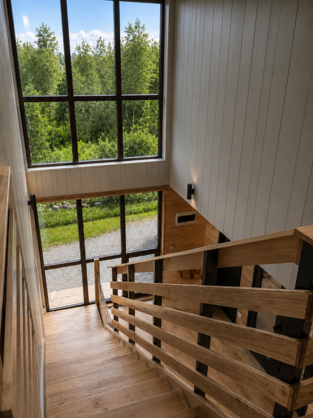Escalera de madera con diseño moderno en casa de doble altura