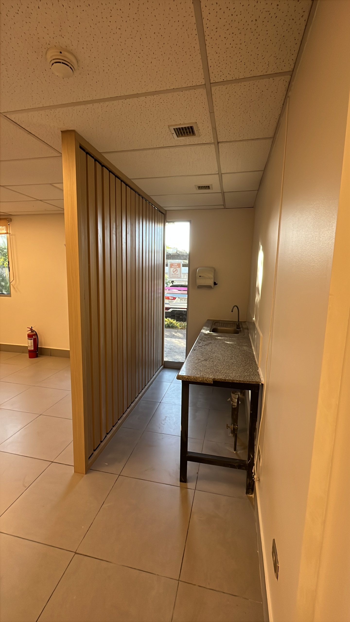 Kitchenette con divisor de listones en oficina remodelada